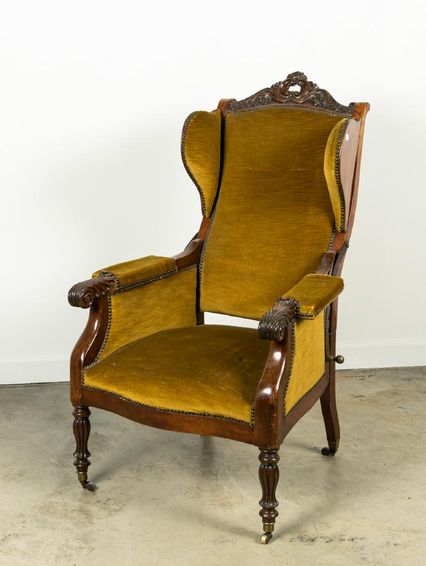 19th C. Upholstered & Studded Reclining Armchair: American, 19th century A carved wood and upholstered mechanical reclining armchair on casters having headrests and brass nailheads Unmarked Approx. h. 48", w. 28", d. 29.5"