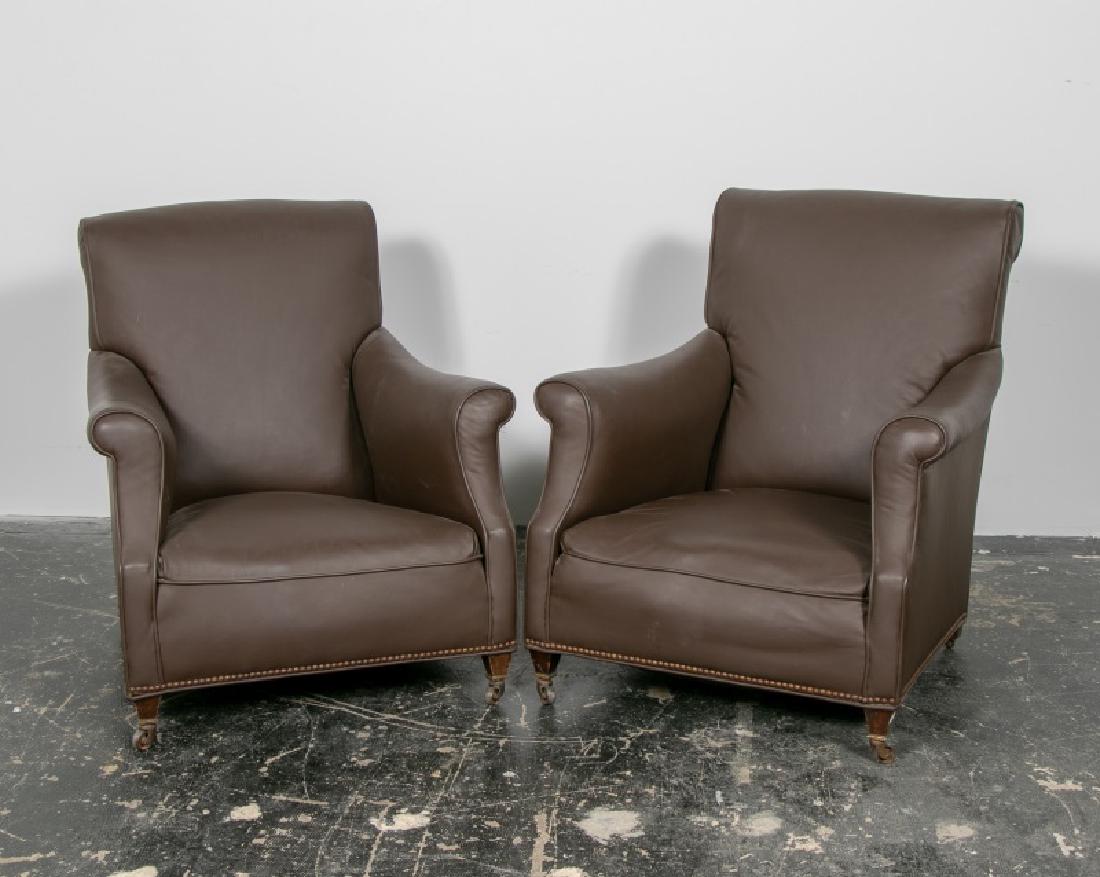 Pair, Brown Faux Leather Club Chairs: American, 20th century. A pair of brown faux leather club chairs, each chair resting on two stationary back legs and two front legs on casters. Approx. H. 36", W. 31.5" D. 34"