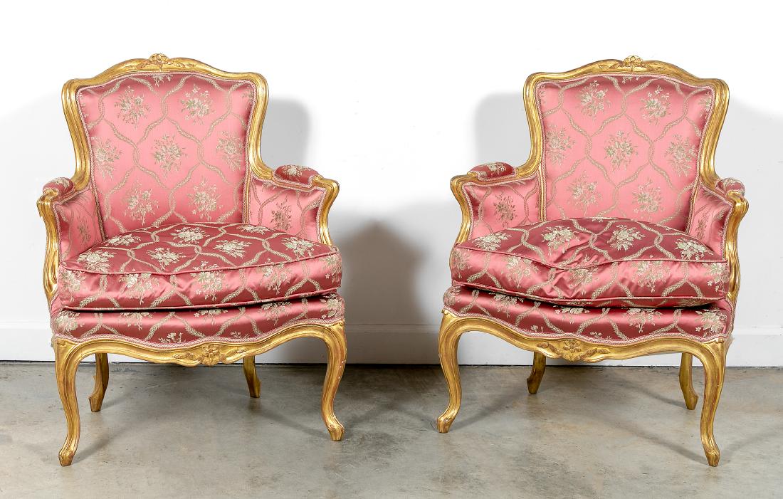 Pair, Louis XV Style Giltwood Bergere Chairs: 20th Century, Pair, Gilt Wood Framed Bergeres, Louis XV Style. With molded frames and floral crest carving, rose ground floral fabric, loose cushion seats. 34.5" H, 28.5" W. Provenance: From a promine