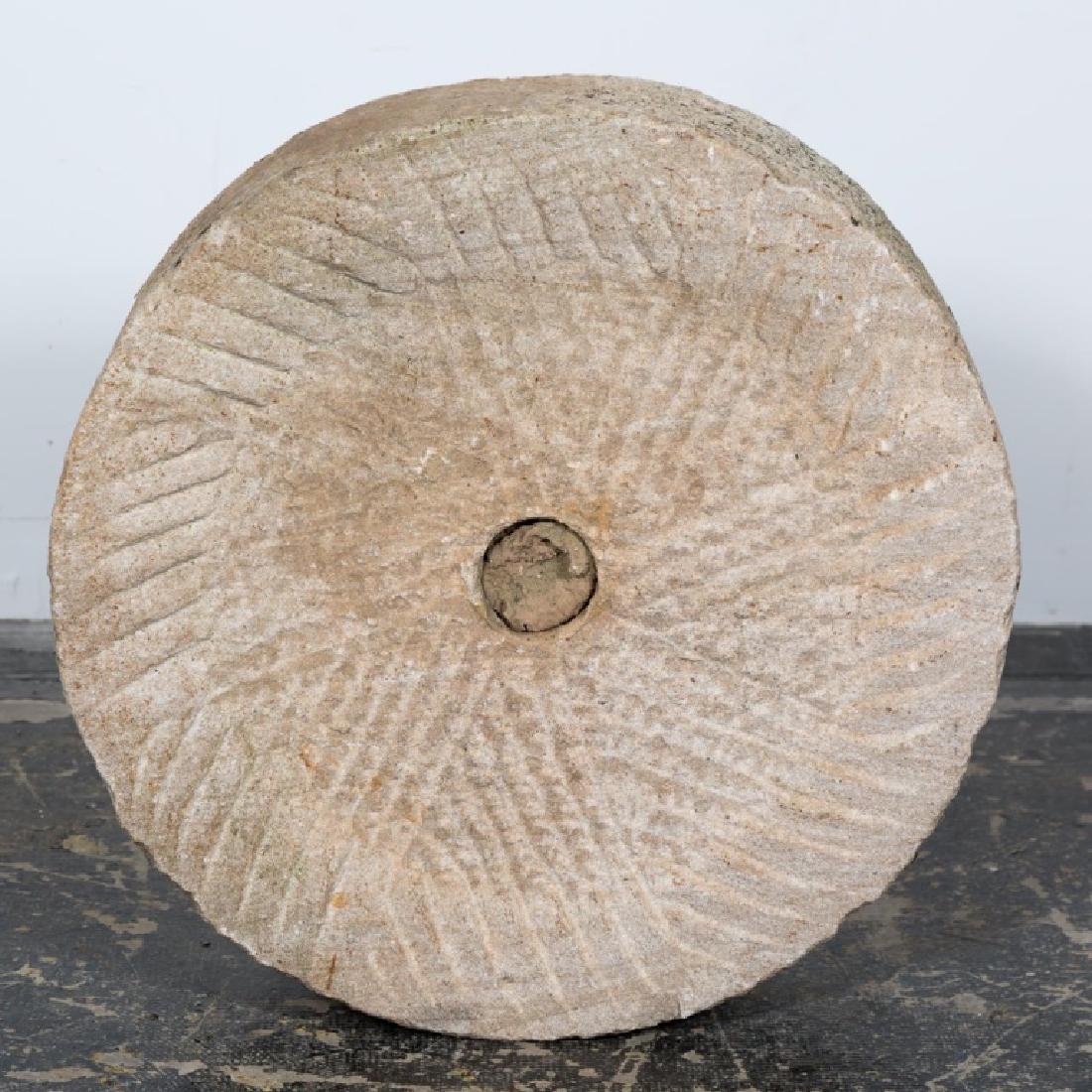 19th Century Chinese Limestone Millstone: Chinese, 19th century; pierced center with radiating geometric carving. Approx. d. 24.5, h. 6.5".