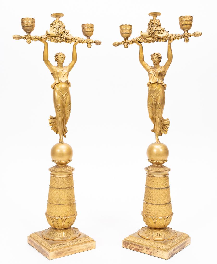 Pair, Bronze Ormolu Empire Candelabrum, c.1875: Pair, bronze ormolu Empire figural candelabrum. French, circa 1875; classical maidens holding aloft a rod decorated with florals, grapes, musical instruments, with two lights and a central platform; o