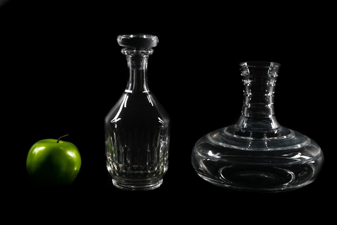 Group of Two Baccarat Crystal Decanters: Baccarat. Two crystal decanters comprising one wine decanter and one spirits in the Canterbury pattern with replacement crystal stopper. Each with acid etched mark to underside. Taller approx. h. 9.5"