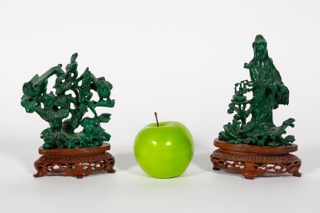 Two Carved Malachite Figures on Wooden Bases: Chinese, 20th century, two carved malachite hardstone figures on fitted wooden bases. a) Quanyin of the South Sea (or Quanyin with a fish basket), standing on a lotus leaf on the waves - 6" h., 4.25"
