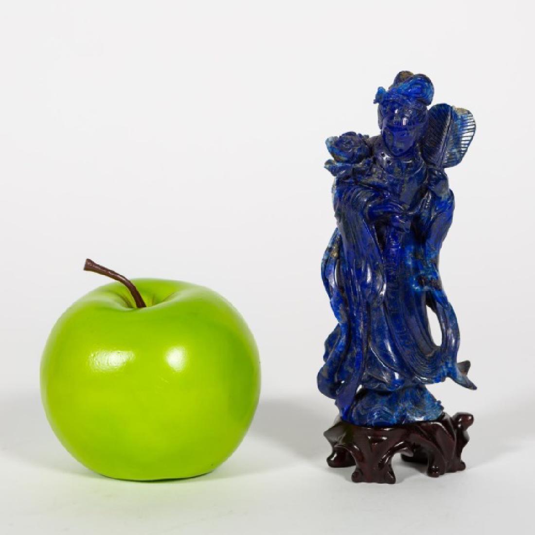 Carved Lapis Quanyin on Stand: 20th century, Chinese, caved lapis lazuli figure of Quanyin, with wood stand. Quanyin holding fan and flower wearing flowing robe. 5.25" h., 2.5" w. (without stand)
