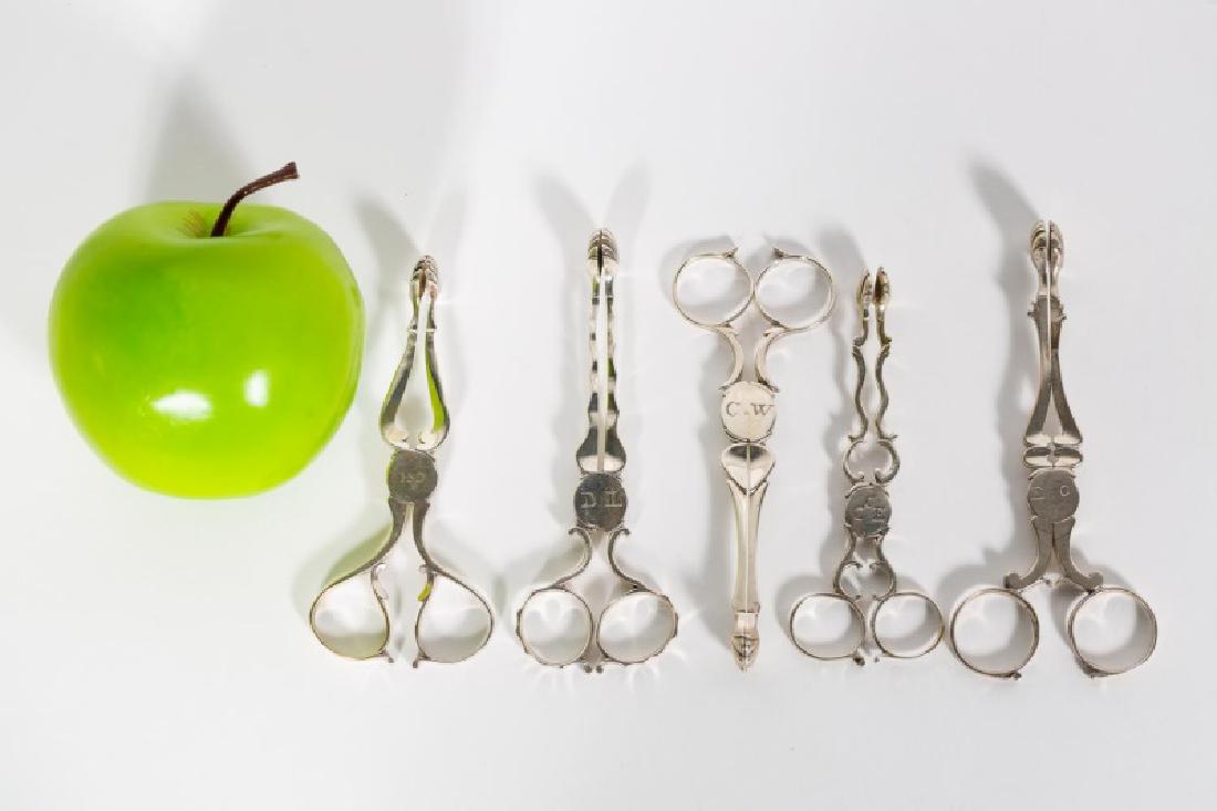 Five English Georgian Silver Sugar Tongs: 18th century, English, sterling silver, five pair of sugar nips/tongs. George III, hallmarked (rubbed), all with early monograms. Approx. 4.5" - 5.25" L, 5.365 ozt. total weight. Provenance: From the 