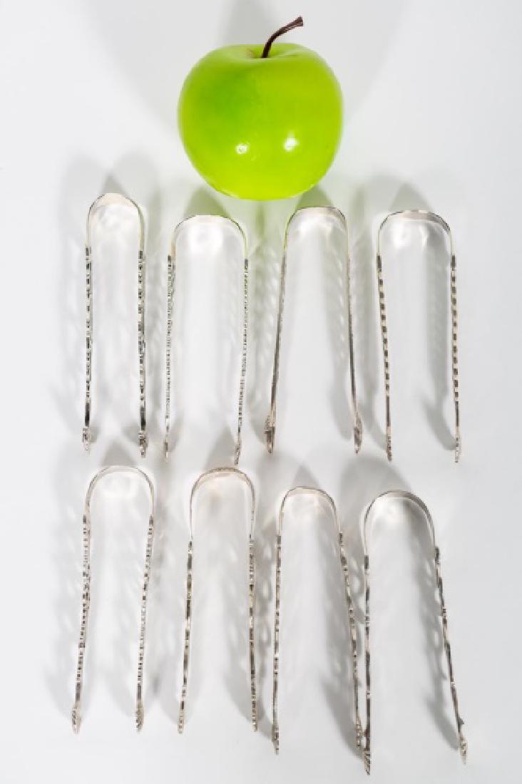 Eight English George III Silver Sugar Tongs: Late 18th century, English, eight sterling silver pierced & engraved sugar tongs. George III, hallmarked, no city marks. All engraved with monograms or crests. Approx. 5.125" - 5.5" L, 9.955 ozt. tota