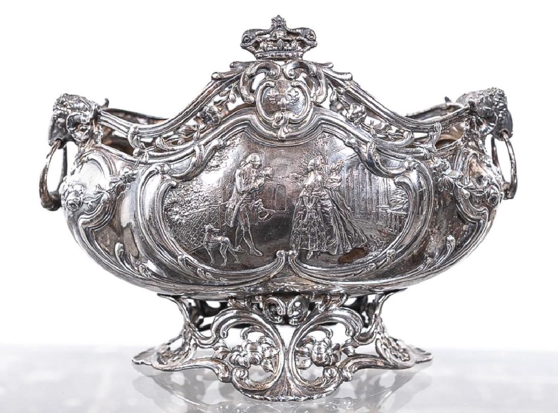 German Hanau .812 Silver Repousse Footed Bowl: German Hanau .812 silver repousse footed bowl. B. Neresheimer & Sohne or Ludwig Neresheimer & Co.; boat form; with armorial crests, figural panels; ram's head handles; on a pierced foliate base. Marke