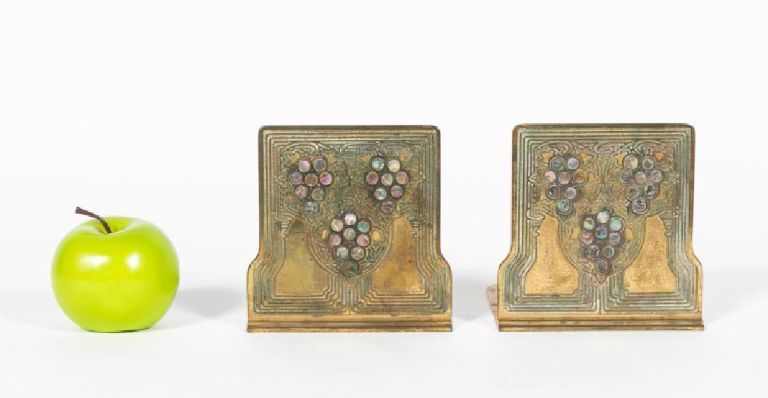 Pair, Tiffany Studios Bronze "Abalone" Bookends: First quarter 20th century, Tiffany Studios (American, 1895-1933); gilded bronze with abalone discs; Arts and Crafts stylized grapes and leaves contained with a repeating border. Marked Tiffany Studio