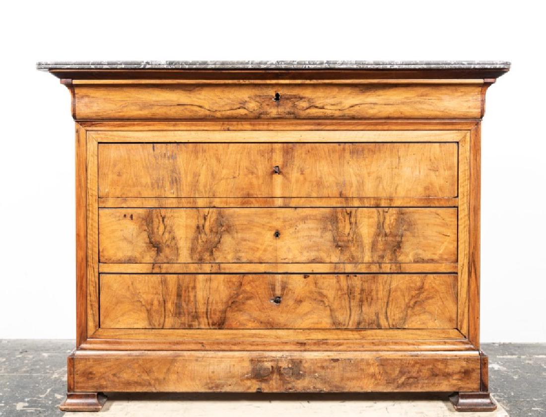 19th C. Louis Philippe Walnut Marble Top Commode: 19th century, French; black/grey top on a walnut veneered case; concealed frieze drawer with three conforming drawers below; rising on volute feet. Approx. h. 37.875", w. 50.5", d. 23".