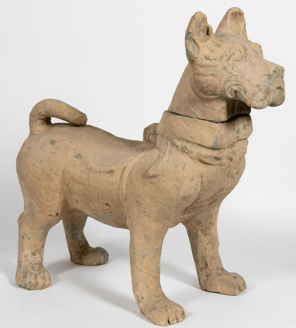 Large Chinese Han Dynasty Earthenware Dog: Chinese, Han Dynasty. The large dog standing foursquare with alert pose, head erect and ears perched and tail curled. The head attached to the body just about a modeled collar. Approx: h. 26.75". Prov