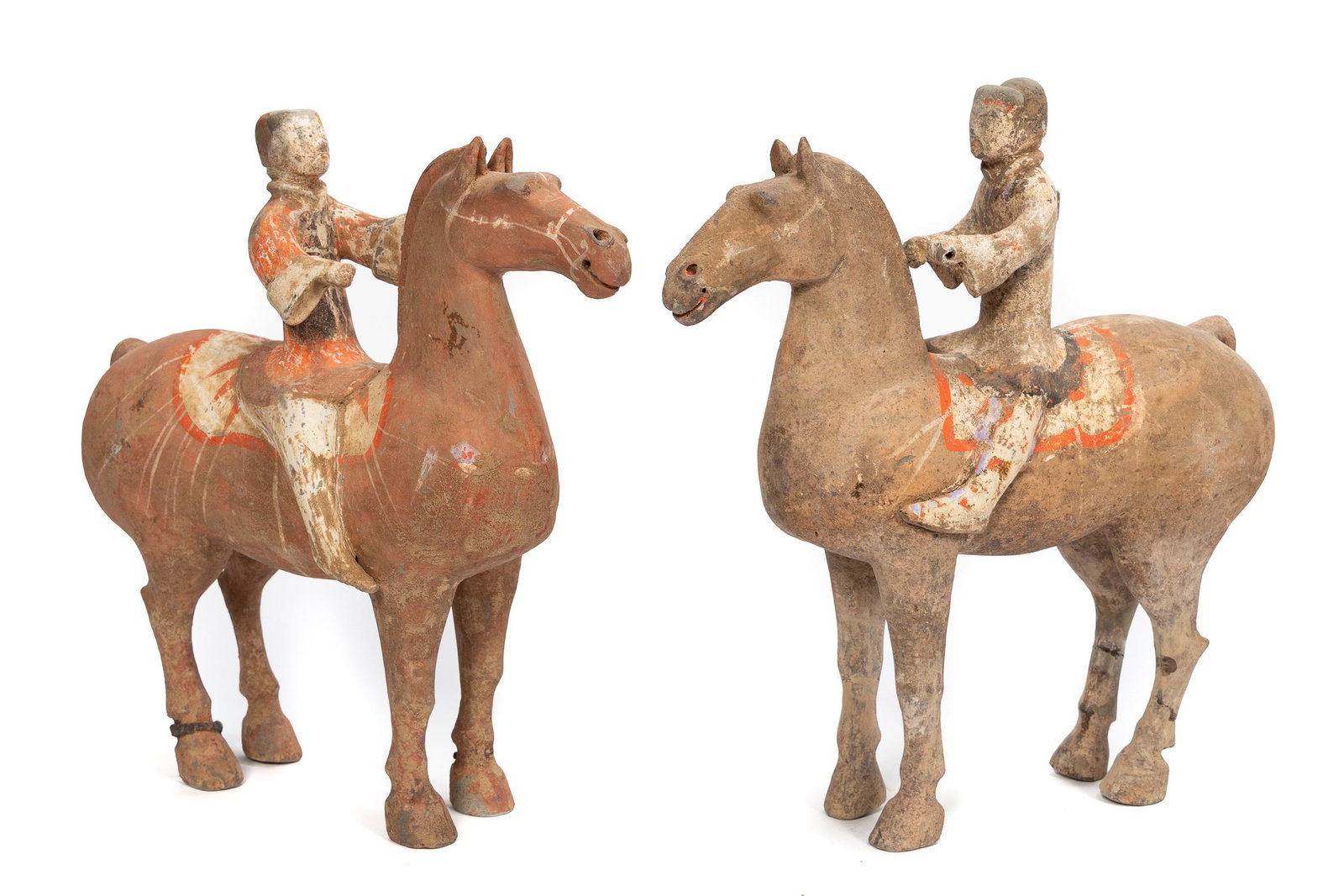 Two Han Dynasty Equestrian Pottery Figures: Chinese, Han Dynasty. One figure with red pigment, the saddles, trimmings, and tassels painted in white with red details, and the other figure painted in red and black, the horse's saddle with white s