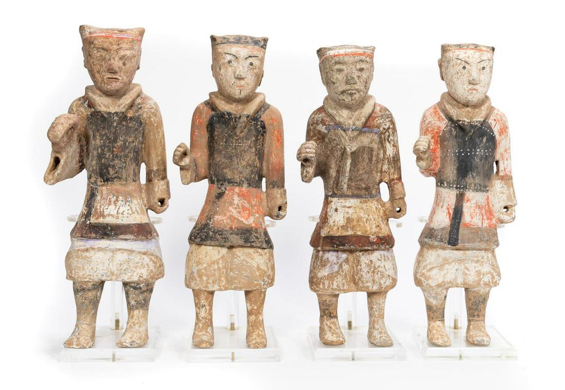 Four Han Dynasty Painted Pottery Warriors: Chinese, Han Dynasty. The four pottery warriors painted in white slip, black armor with red and white undershirt, having flesh colored face with black painted cap and facial features. The figures stan