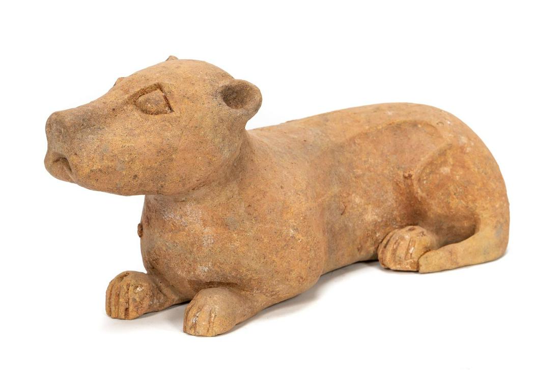Chinese Han Dynasty Pottery Recumbent Dog: Chinese, Han Dynasty. The Han dynasty figure of a recumbent dog depicted with its head held up, tail curled and leaning slightly to one side. h. 7.5" w. 16" d. 6". Provenance: From the Private Collect