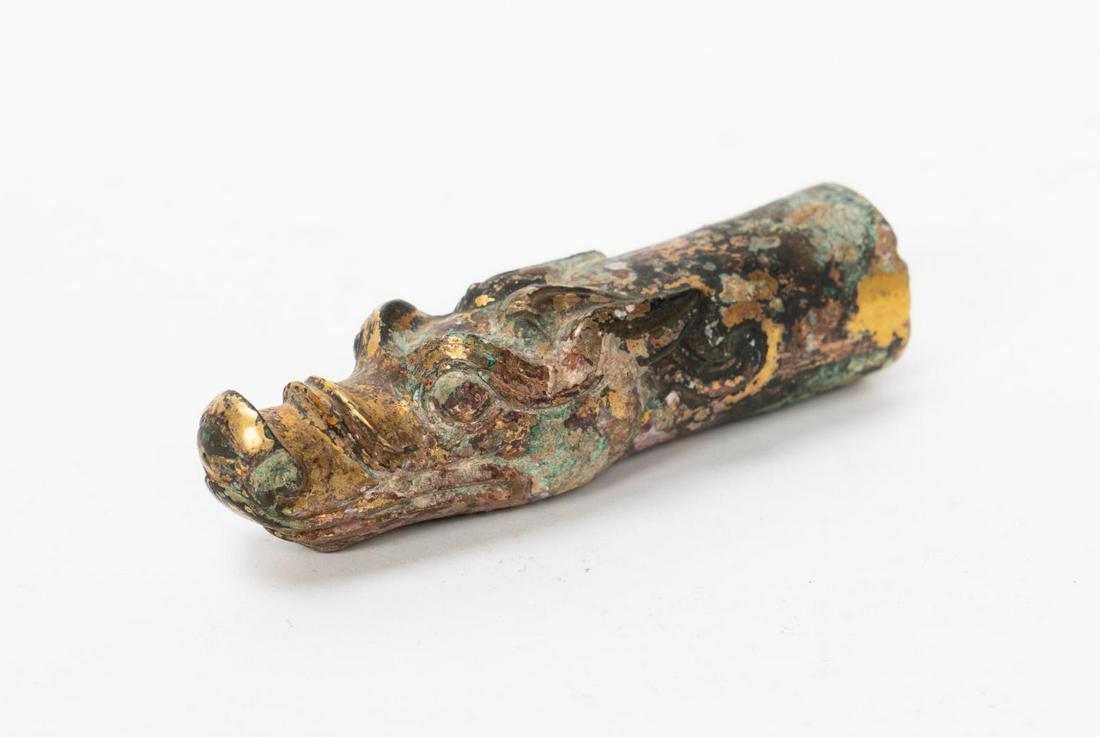 Han Dynasty Gilt Bronze Dragon Chariot Fitting: Chinese, Han Dynasty, the dragon form chariot fitting of tubular form with flared nostrils, large arched eyebrows, and remnants of gilt decoration, length 4". Provenance: From the Private Collection o