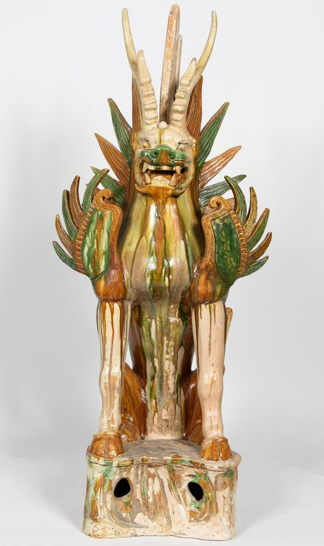 Large Chinese Han Sancai Glaze Earth Spirit: Chinese, Han Dynasty. The large sancai glazed lionese seated winged earth spirit having antlers grown from the brow with flame form incised fins behind the ears and running down the back. The shoulder