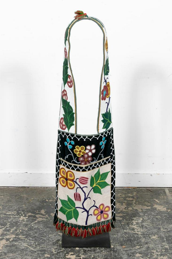 E. 20th C. Native American Beaded Bandolier Bag: Native American, first quarter 20th century. A multicolored bead, silk and deer hide martingale from the Northern Plain possibly Plateau region, heavily decorated with leaves and small flowers and tas