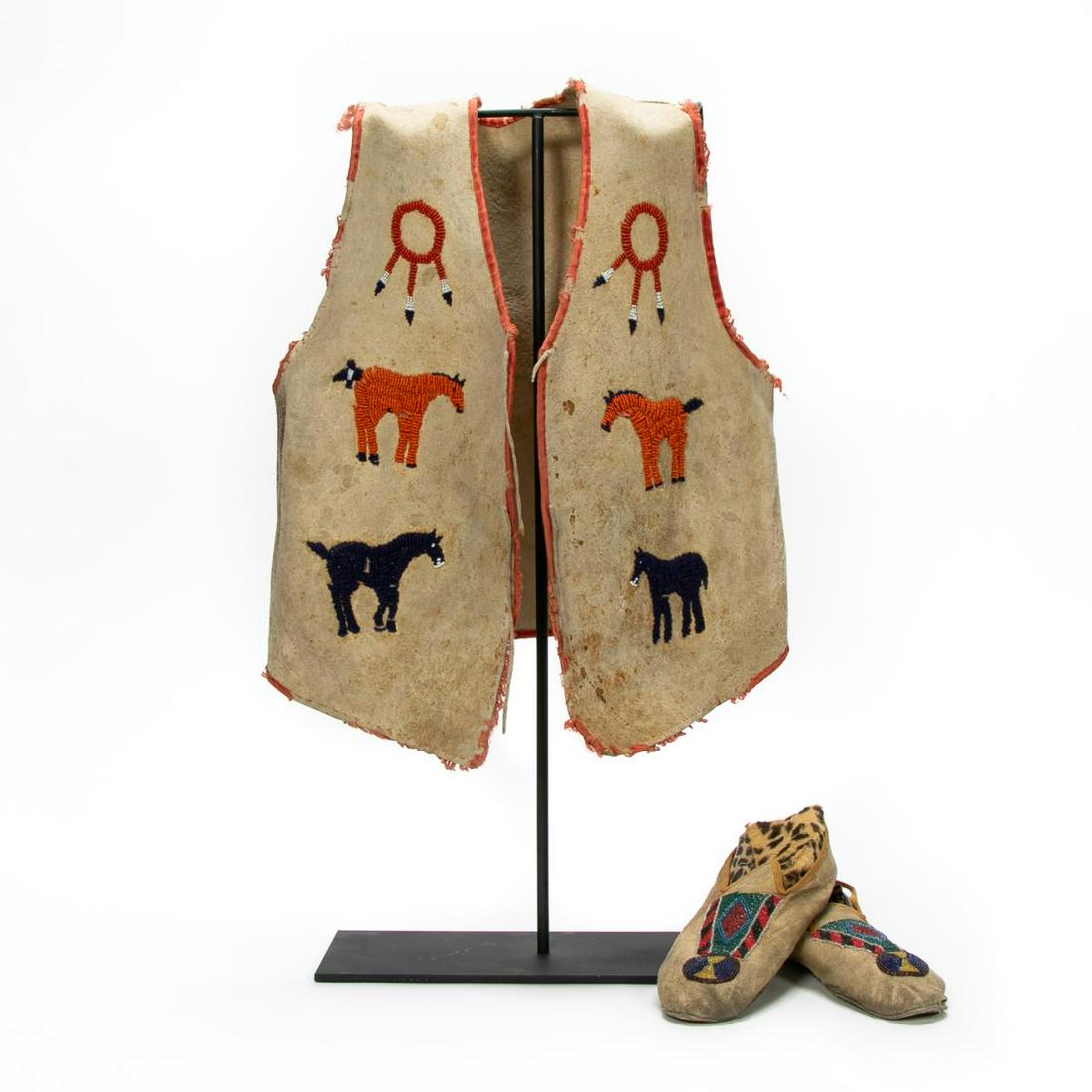 Native American 2 Pc. Set, Beaded Vest & Shoes: American, 20th century. A set of Native American beaded clothing accessories comprising of a Plains pictorial boys hide and beaded vest incorporating an orange and blue horses and beaded dream catcher