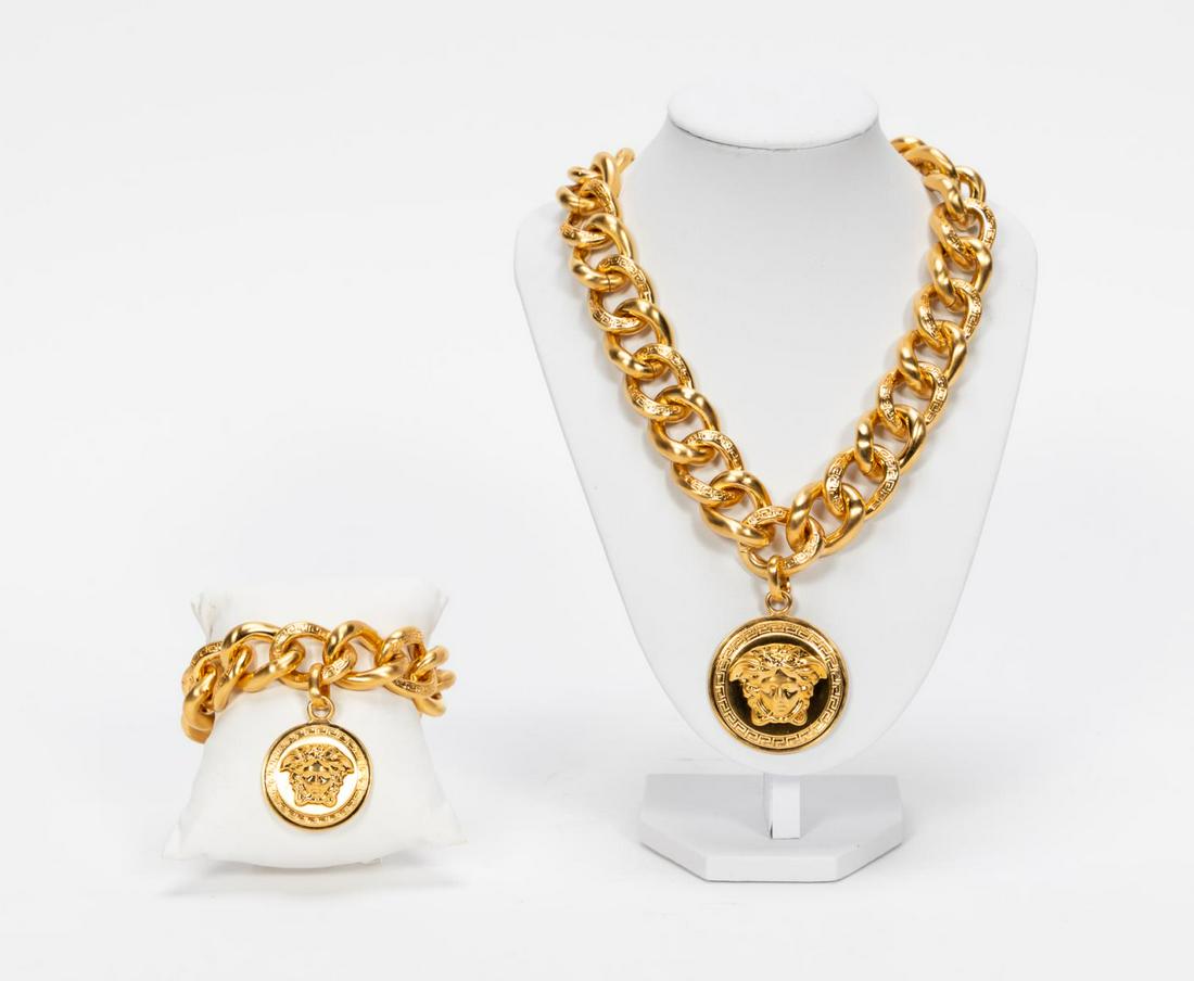 Versace "Medusa" Logo Necklace & Bracelet Set: Gianni Versace Fashion (Italian, founded 1978). A two-piece set of "Medusa" logo jewelry including a necklace with large drop medallion, Greek key accents to each chain and a matching bracelet. Marked