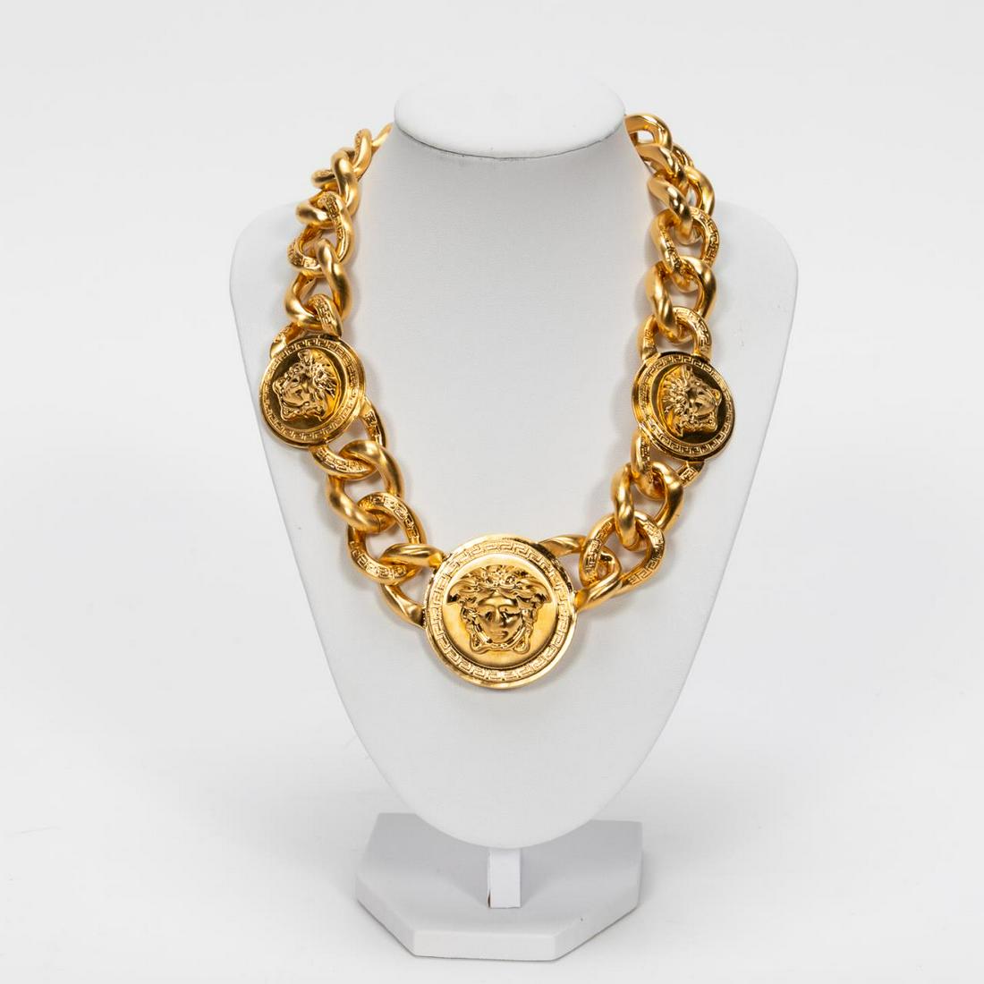 Versace "Medusa" Logo Necklace W/ Box: Gianni Versace Fashion (Italian, founded 1978). A gold tone "Medusa" logo fashion necklace with three large medallion and Greek key accents to each individual chain. Marked "Versace" to snap lock clas