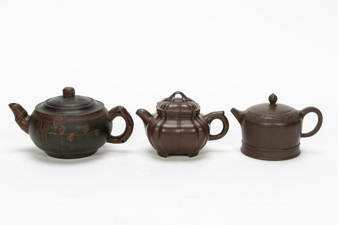 Three, Signed Chinese Yixing Stoneware Teapots: Chinese. Three Yixing stoneware teapots including a large round pearl bamboo motif teapot with foliate decoration to the exterior, a gaojing ian hu shaped teapot decorated with heavy calligraphy and a