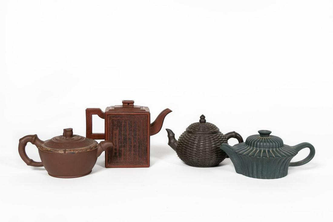 Four Chinese Yixing Zisha Clay Teapots: Chinese. Group of four finely molded clay teapots comprising a zisha pot with cherry blossoms,a zhu sha pot decorated with a poem, a duan ni dark blue-green lobed pot and a duan ni dark brown pot. All