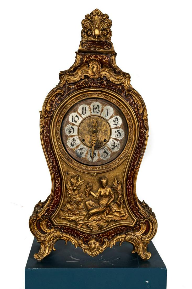 Louis XIV Style Cartel Clock, Circa 1900: Likely Continental, late 19th to early 20th century. Wooden and gesso rococo style clock in the Louis XIV taste having a gilded foliate decorated case having a figural door, the dial with roman numera