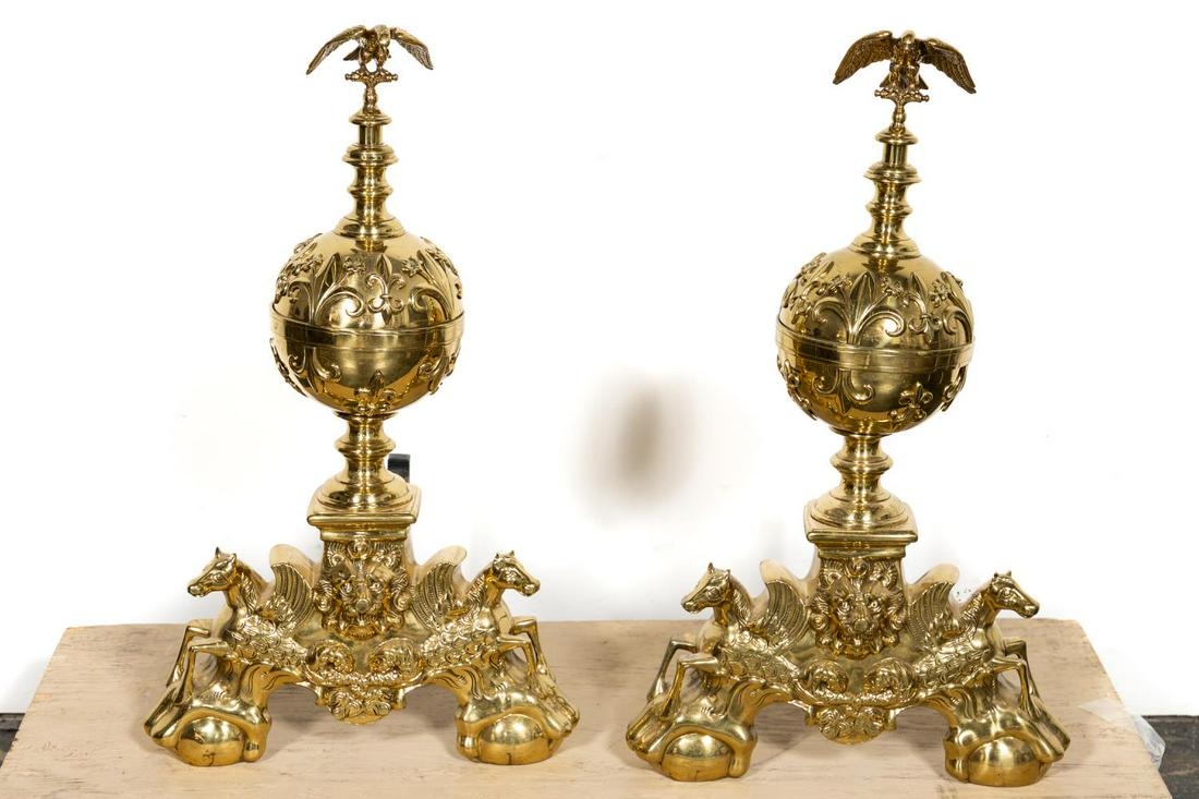 Pair, Large Baroque Style Polished Brass Andirons: Likely Continental, 20th century. Pair of large baroque style brass ball andirons in the Louis XIV taste decorated with fleur-de lis, surmounted by eagles and rising on a base with lion masks and flan