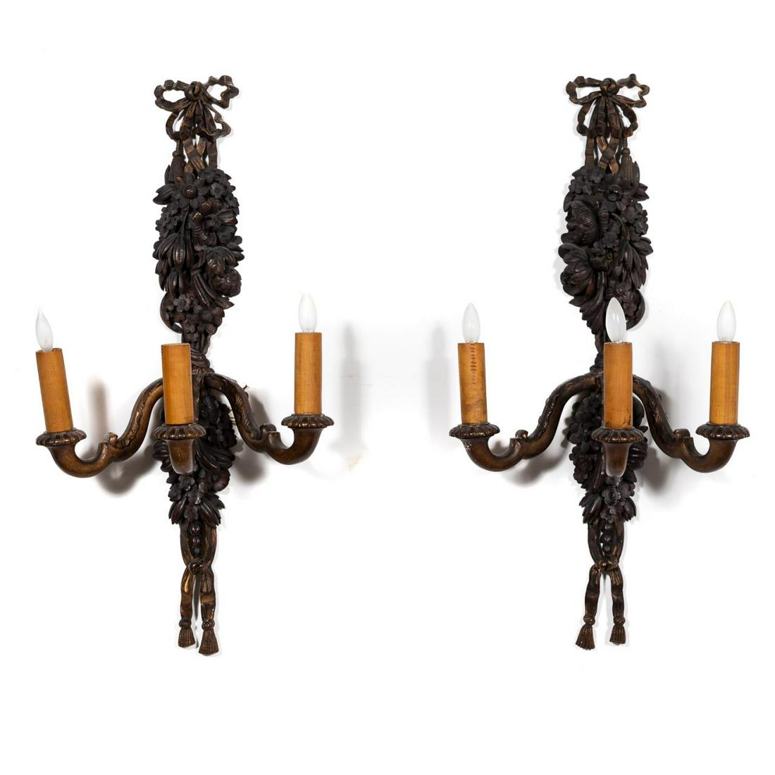 Pair, French Baroque Style Carved Wooden Sconces: French, early 20th century. Pair of carved partial gilt wooden three-light sconces in the baroque taste, having ribbon tied boughs of fruits and florals and scrolled arms. Unmarked. Approx. of one, h.