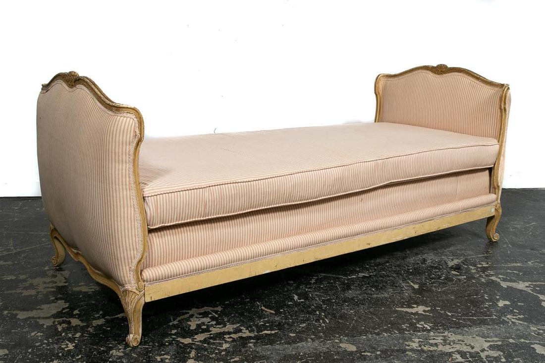 19th C. Louis XV Style Lit de Repos or Daybed: French, 19th century. Distressed painted wooden lit de repos or daybed, having a curved foliate carved frame, loose cushion, upholstered head and foot boards, side rails and rising on whorl feet. Unma