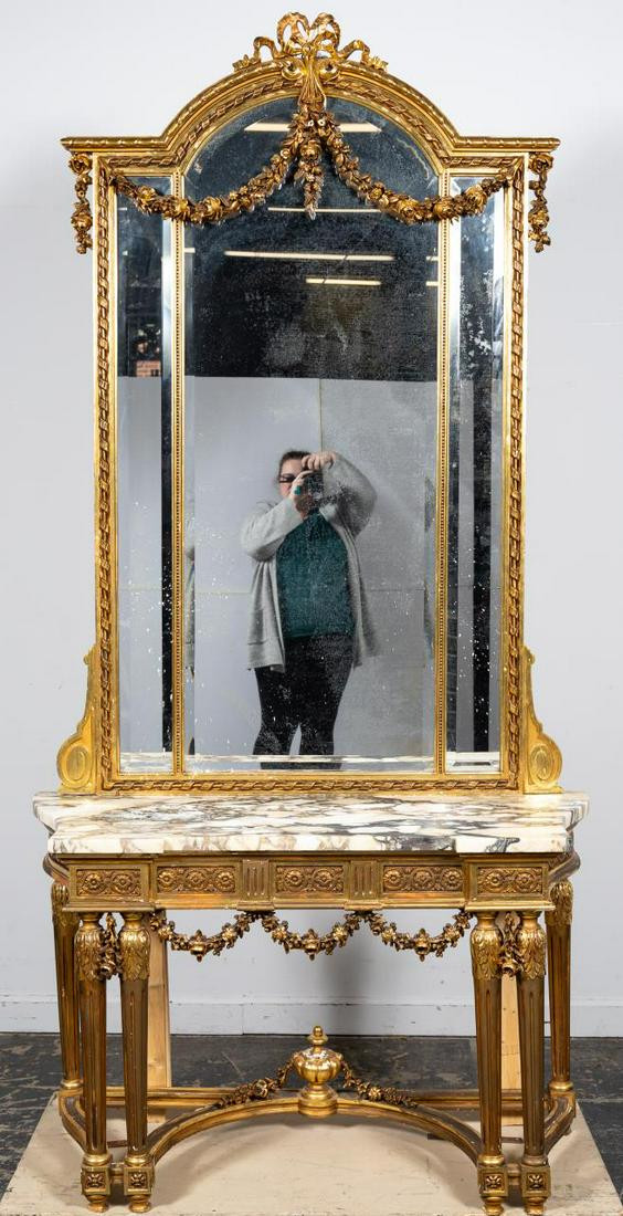 French Gilt Wood Marble Top Console Table & Mirror: French, early 20th century. Louis XVI style gilt wood & gesso marble top console table with mirror, the table with shaped top on conforming base with carved frieze and floral swags and having 6 turned