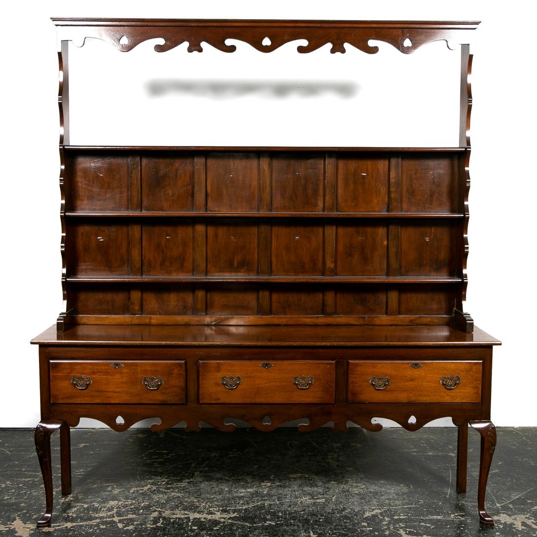 Queen Anne Style Mixed Hardwood Welsh Dresser: American or English, 20th century. Welsh mixed hardwood dresser or cupboard or having a shaped cornice, scalloped and pierced frieze, open upper shelf with two additional shelves below, the lower case