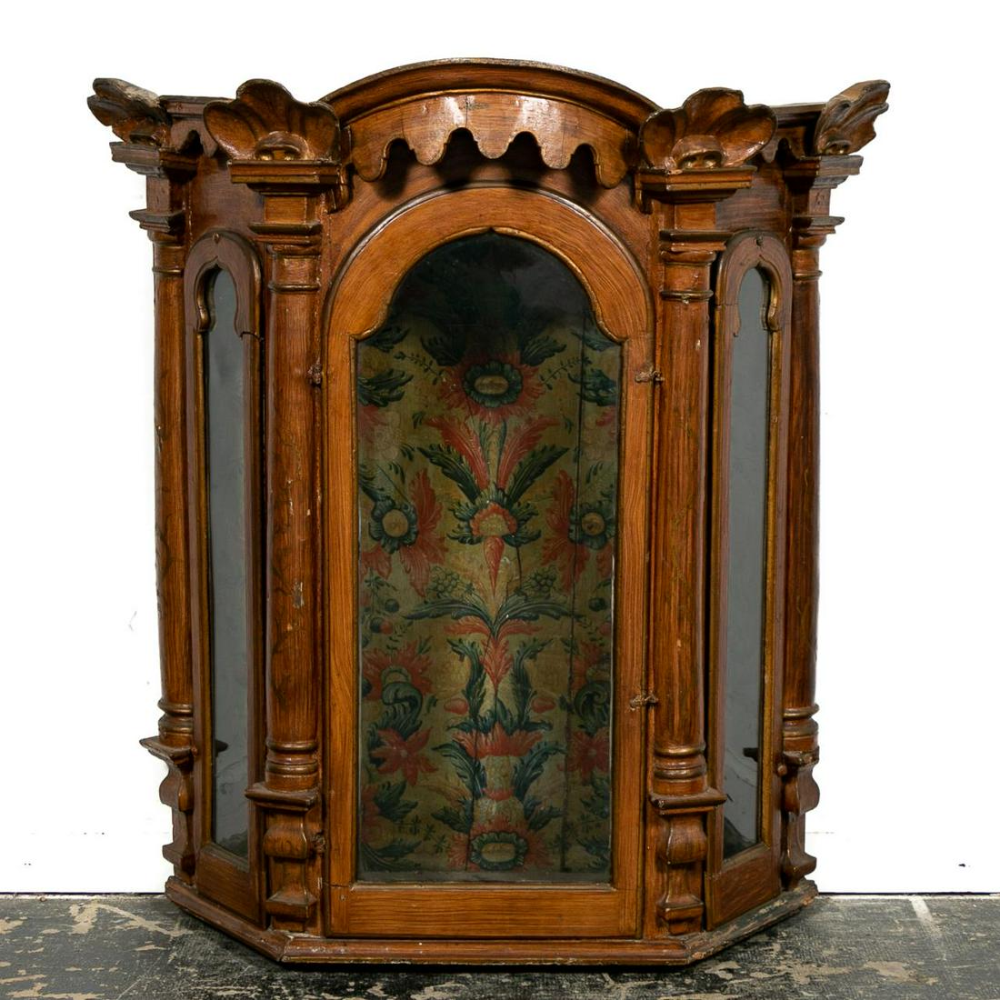 Portuguese Faux Bois Wall Hanging Vitrine, 18th C.: Portuguese, late 18th C. Faux bois painted wooden baroque corner vitrine cabinet having a scalloped cornice with shells supported by pilasters below, the central arched door and flanked by smaller arc