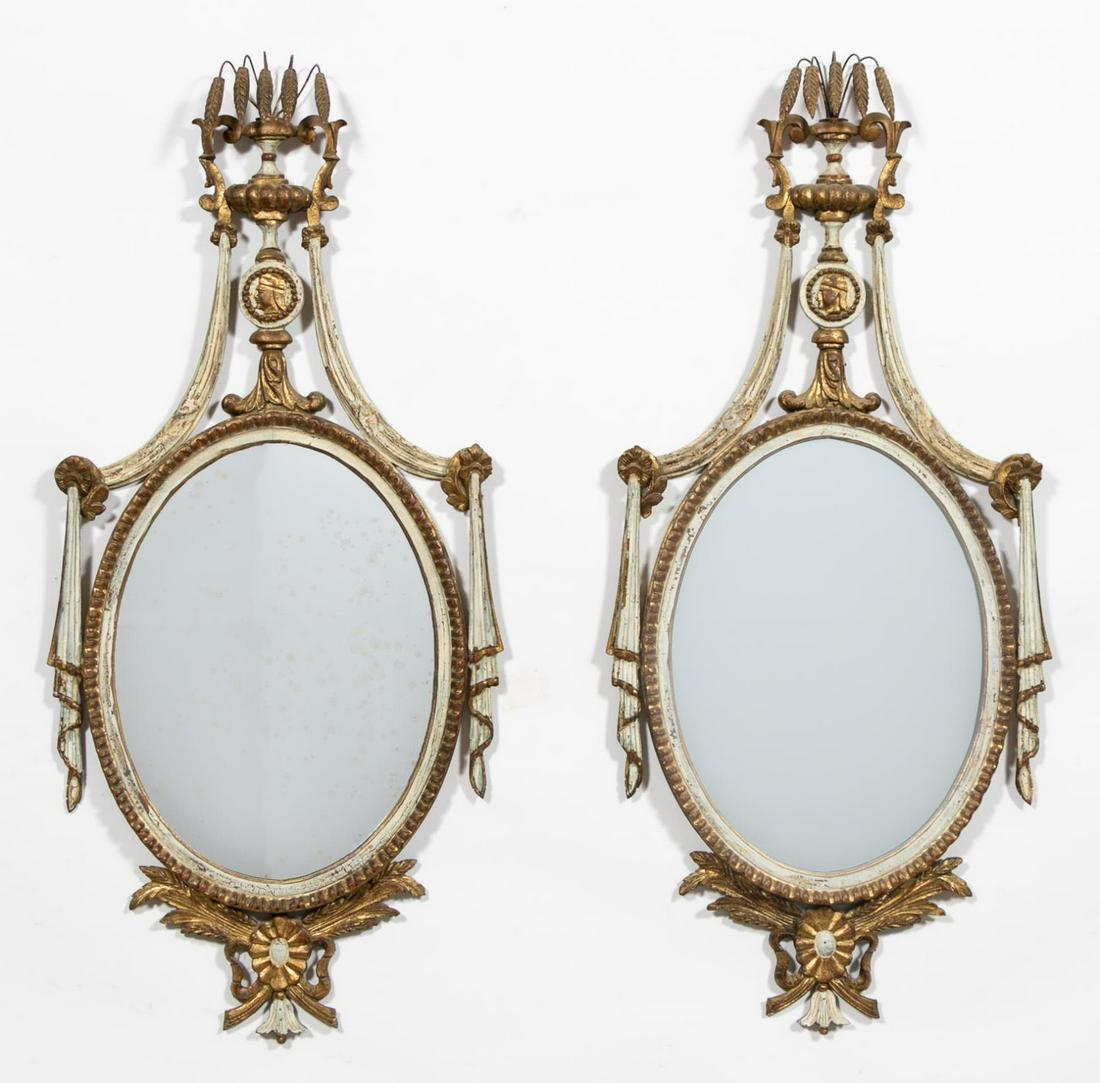 Pair, Neoclassical Style Painted Gilt Oval Mirrors: Italian, 20th Century. Pair of neoclassical style oval gilt and painted wood framed mirrors with oval glasses, wheat crests over drapery motif frames. Approx. 49" x 22.5". Provenance: From a Private E