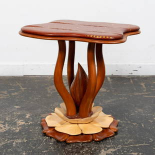 STEVEN SPIRO MIXED WOOD INLAID LOTUS BASE TABLE: Steven Spiro (American, b. 1949), 2003. Contemporary exotic mixed hardwood side or occasional organic form table having a carved top with meandering inlay featuring mother of pearl and an ammonoid, su