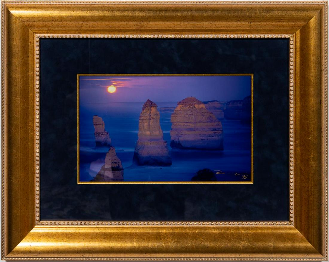 PETER LIK, "MOON GLOW" C-TYPE PHOTOGRAPH: Peter Lik (Australian, born 1959). "Moon Glow" - c-type photograph, signed and numbered to lower right "Peter Lik, 123/450". A vibrant photograph of the sun setting over a rocky cloud. Approx. 11" x 1