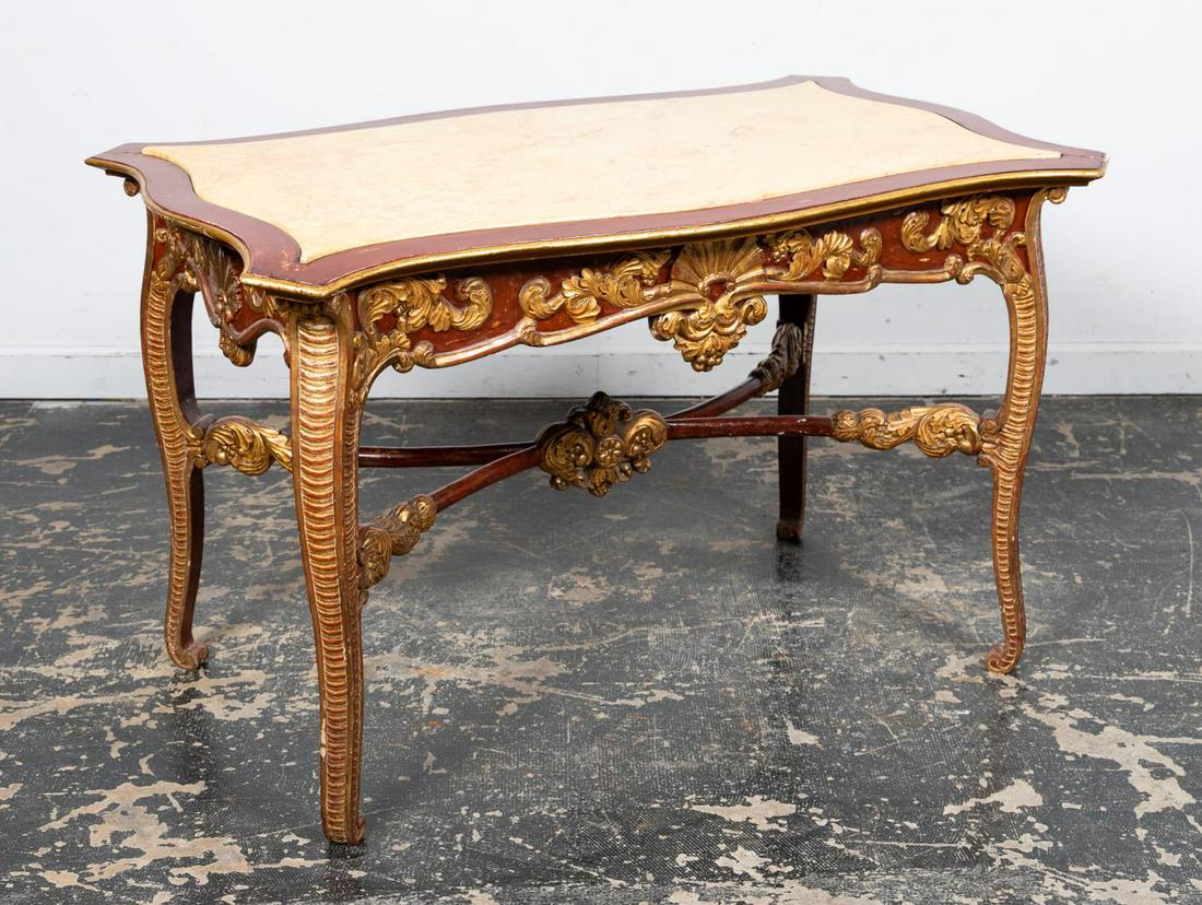 19TH C. ITALIAN ROCOCO STYLE GILT CENTER TABLE: Italian, containing 19th century elements. Carved part-gilt center table in the rococo taste, having later red decoration, faux manufactured "sienna marble" top (acrylic), scrolled foliate apron and r