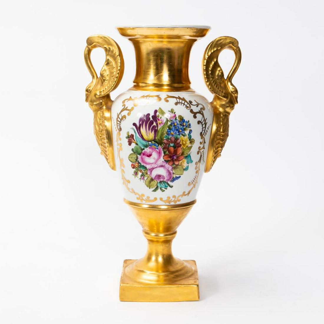 19TH C. GILDED OLD PARIS PORCELAIN FLORAL VASE: French, first half 19th century. Gilded old Paris porcelain urn having swan handles and reserves with polychrome floral decoration. Unmarked. Approx. h. 16", w. 8.75". (handles). Provenance: From the 