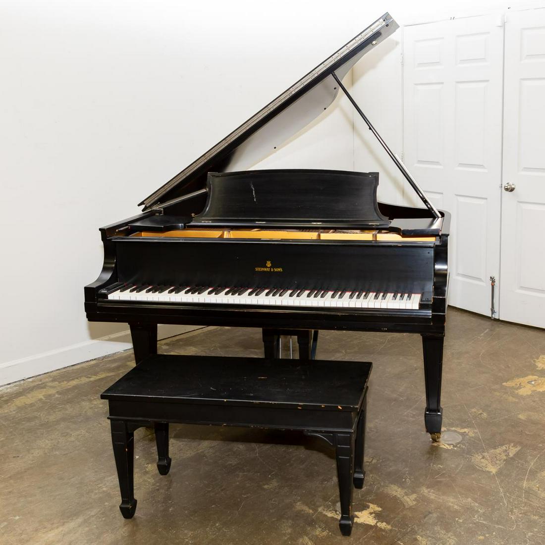 STEINWAY MODEL L BABY GRAND PIANO AND BENCH, 1925: Steinway (American, founded 1853), 1925. Model L ebonized finished laminated maple baby grand piano, rising on tapered legs with spade feed, accompanied by a matching bench with lift-top storage. Mark