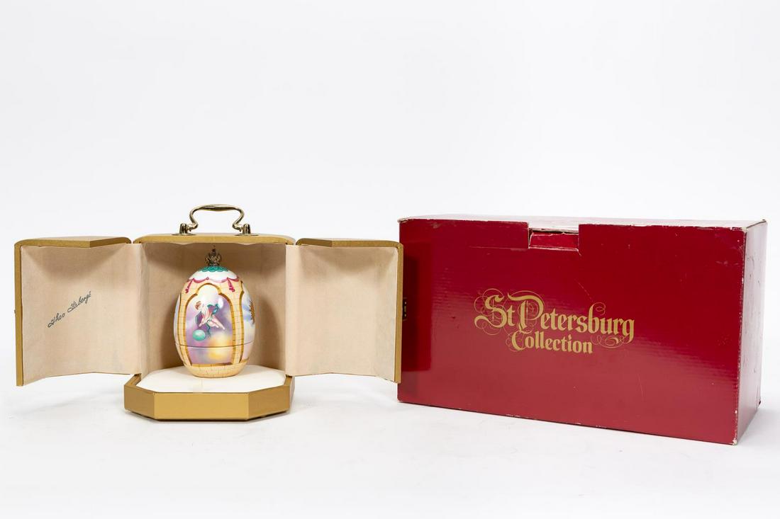 THEO FABERGE "THE PHOENIX EGG" PORCELAIN, STERLING: Theo Faberge (English, 1922-2007). A hand-decorated two piece porcelain egg which separates to reveal a sterling silver phoenix emerging from the flame; topped with a vermeil crown, produced in 1990. 