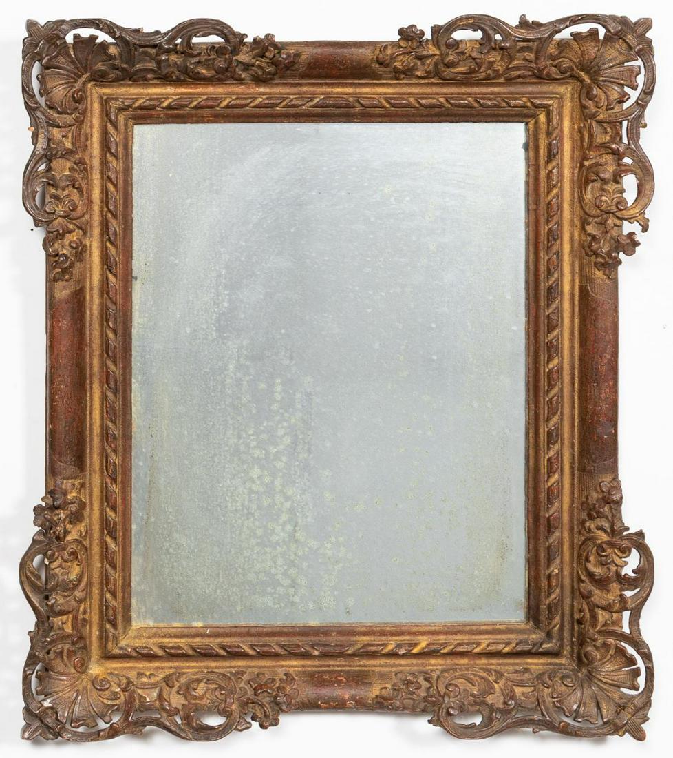 CONTINENTAL BAROQUE STYLE GILTWOOD MIRROR: Continental, mid to late 19th century. Giltwood and composition mirror in the baroque taste having a frame with scrolled foliate, shells and ribbon detail containing a distressed silvered plate. Unmar