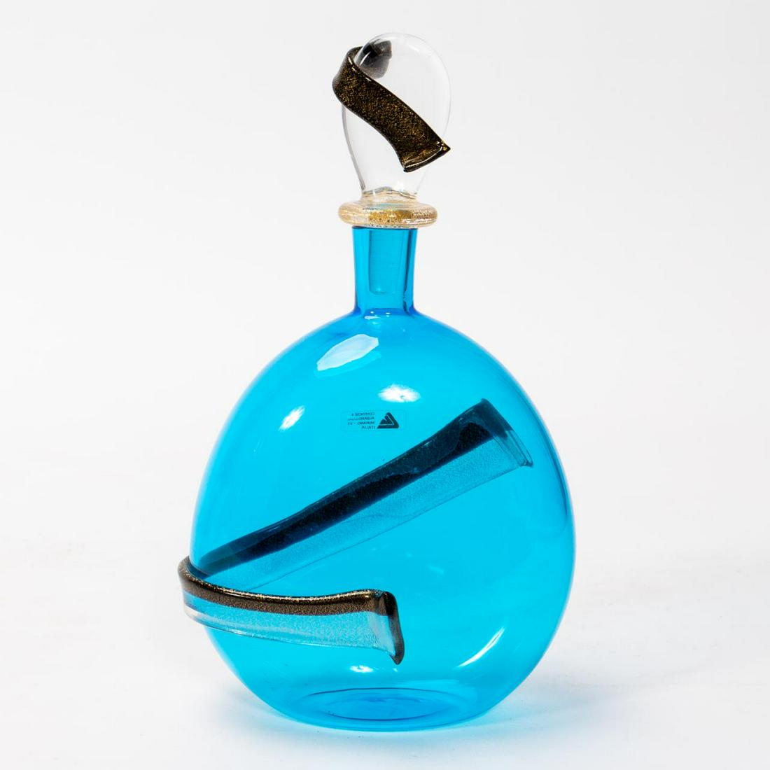 CENEDESE & ALBARELLI, MURANO ART GLASS BOTTLE: Maurizio Albarelli (Italian, 20th century), Gino Cenedese (Italian, 20th century). A two piece Murano blue art glass bottle with an applied clear to black strap and with gold flaking. With applied sti