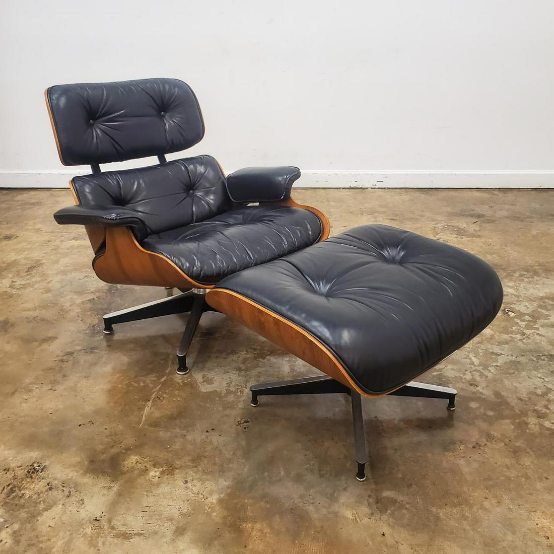 EAMES ROSEWOOD CHAIR & OTTOMAN, C. 1965-78: Charles and Ray Eames (American, 20th century), for Herman Miller (American, founded 20th century), 1965-1978. Mid Century Modern model 670 black leather lounge chair with Brazilian rosewood veneered 