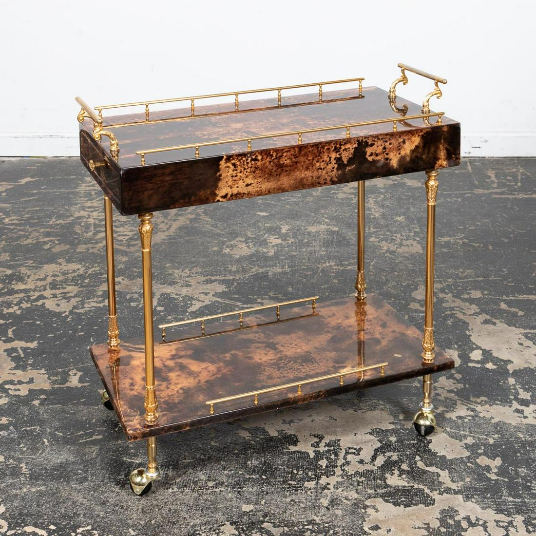 ALDO TURA LACQUERED GOATSKIN & BRASS BAR CART: Aldo Tura (Italian, 1909-1963), mid 20th century. A Mid Century Modern lacquered brown and tan goatskin and brass bar cart. Apparently unmarked. Approx. h. 32.5", w. 31.5", d. 15".