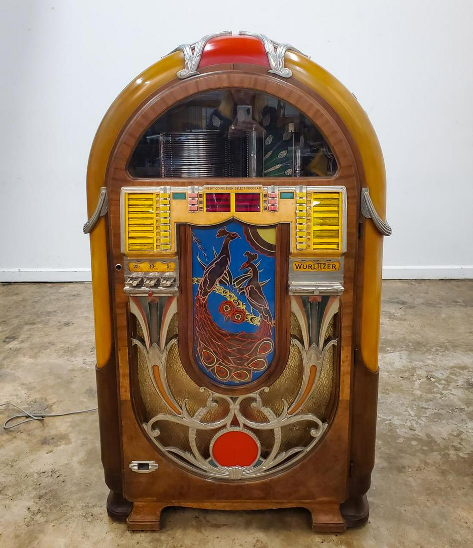 WURLITZER MODEL 850 "PEACOCK" GOLDEN AGE JUKEBOX: Wurlitzer (American, founded 1853), circa 1941. A golden age model 850 "Peacock" jukebox with chrome accents, twenty-four disc selection changer and a vivid peacock motif. Marked with matching case an