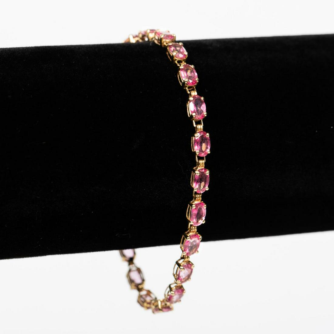 10K YELLOW GOLD & PINK TOPAZ BRACELET: A 10k yellow gold bracelet set with twenty-one pink topaz stones. Marked for 10k gold quality. Total length approx. 7.25". Total weight approx. 5.7g.