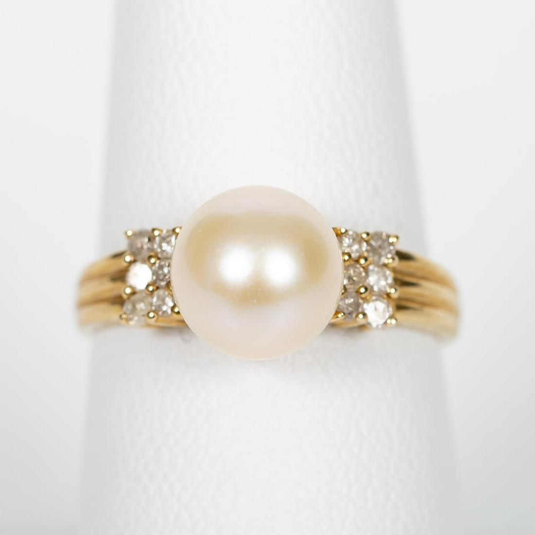 14K YELLOW GOLD, AKOYA PEARL & DIAMOND RING: A 14K yellow gold ring with a central mounted Akoya pearl and flanked by three rows of twelve total diamonds. Marked “G 14K, ES, 021”. Approx: 7 (ring size); with a total approximate weight of 3.5