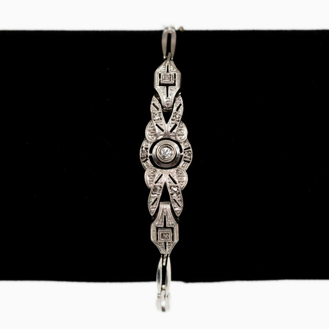 ART DECO PERIOD, 12K WHITE GOLD & DIAMOND BRACELET: American, circa 1925. A 12K white gold Art Deco bracelet with one central round cut diamond flanked with eight small round cut diamond chips and having ten links with a box clasp closure. Apparently u
