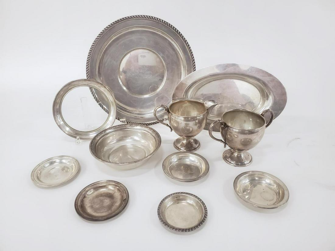 ELEVEN STERLING SILVER TABLE ACCESSORIES: Mostly American, 20th century. An eleven piece grouping of sterling silver table accessories including a Preisner Silver Company plate (9.75"), a bread tray or plate (9.5"), a Wallace bowl (5.5"), an