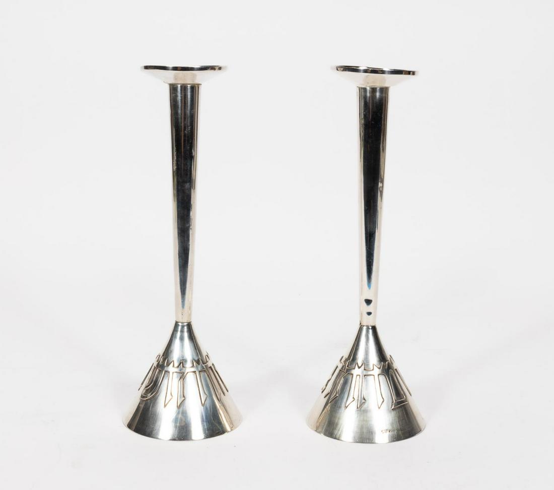 WOLPERT, "LIGHT & HAPPINESS" SILVER CANDLESTICKS: Ludwig Yehuda Wolpert (German / American, 1900-1981). A pair of sterling silver "Light and Happiness" candlesticks with a tapered design and Hebrew lettering to base. Marked to base "Sterling Silver, 