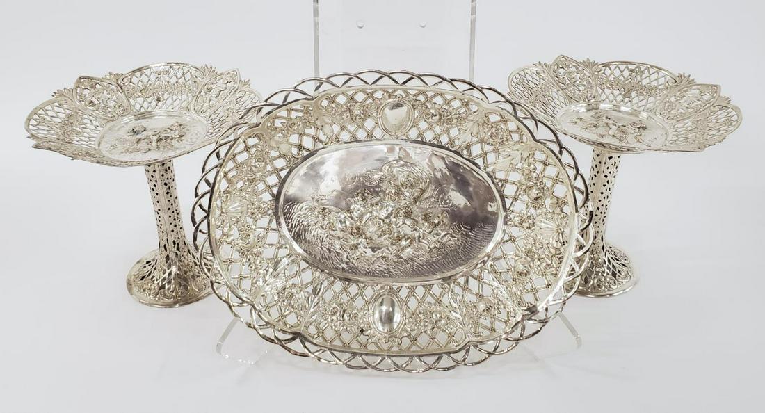 THREE, CONTINENTAL SILVERPLATE TABLE ARTICLES: Continental, likely German, early 20th century. A three piece grouping of silverplated table articles including a pair of tazzas (h. 8.5") and centerpiece bowl (w. 14.5") each having pierced surface w